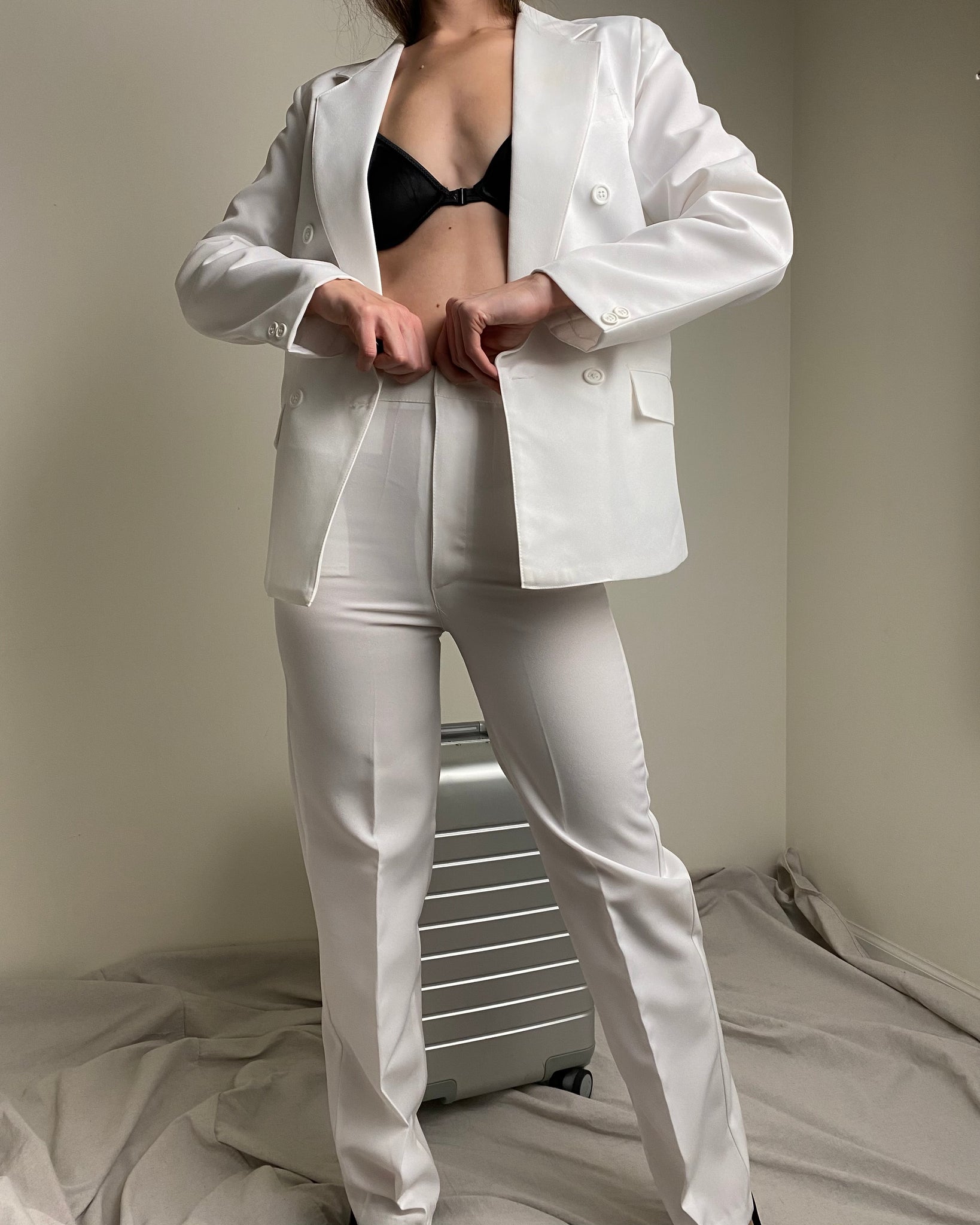 Premium Photo | A model wears a white suit with a black shirt and white  pants.